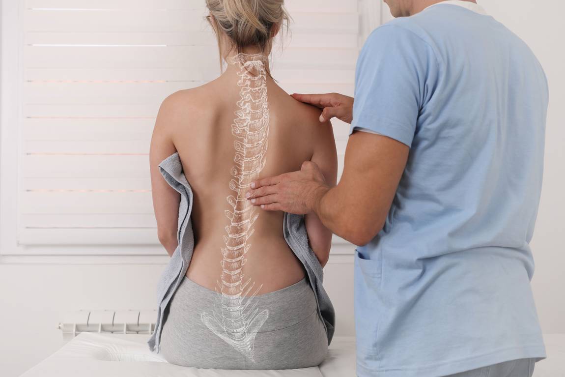 Eine medizinische Fachkraft untersucht den nackten Rücken einer Frau, wobei eine digitale Illustration der Wirbelsäule eingeblendet wird, um die Ausrichtung der Wirbelsäule in einer klinischen Umgebung zu verdeutlichen.